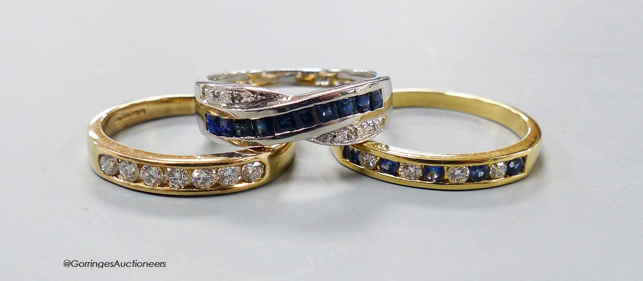 A modern 18ct gold and channel set sapphire and diamond half hoop ring, size R, gross 3 grams and two modern 9ct gold and gem set rings, gross 4.3 grams